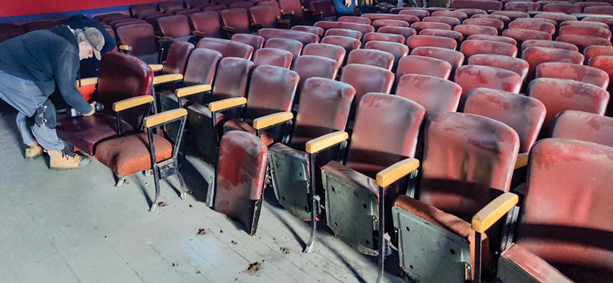 Old burgundy chairs with wooden arms in the old Roxy Theatre in Coleman.