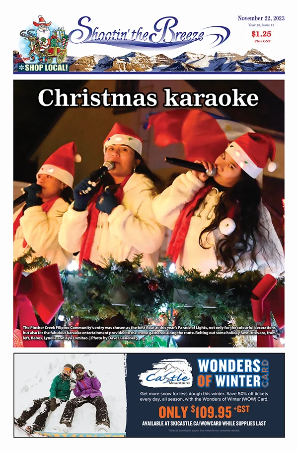 Three girls in Santa hats singing on front page of Shootin' the Breeze Pincher Creek