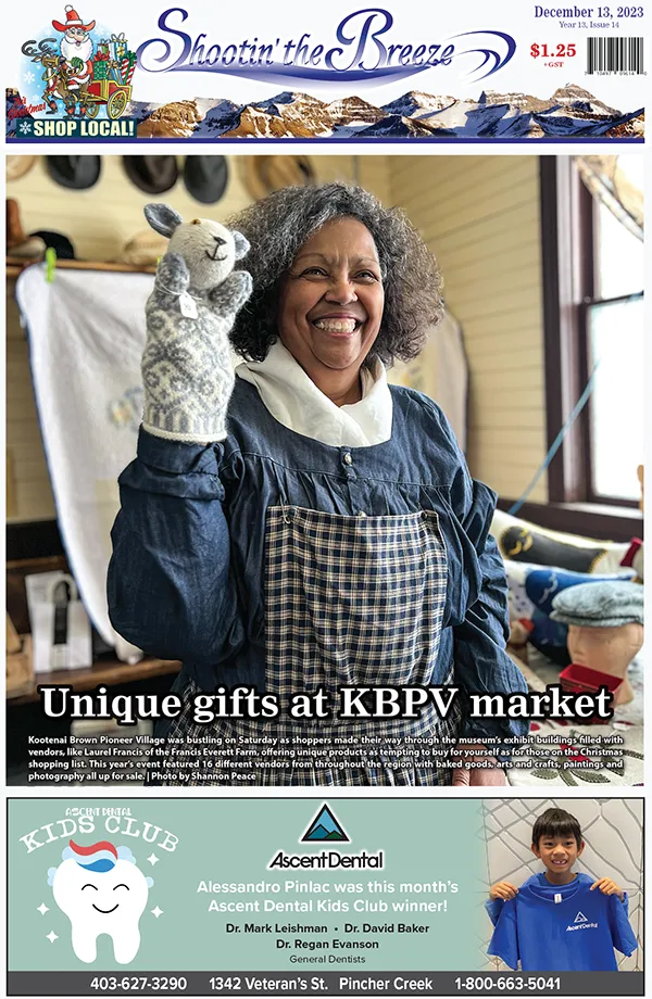 Laurel Francis — a black woman with a big smile — shows a grey and white bunny puppet at the Kootenai Brown Pioneer Village Christmas Market in Pincher Creek, on the front page of Shootin' the Breeze newspaper.
