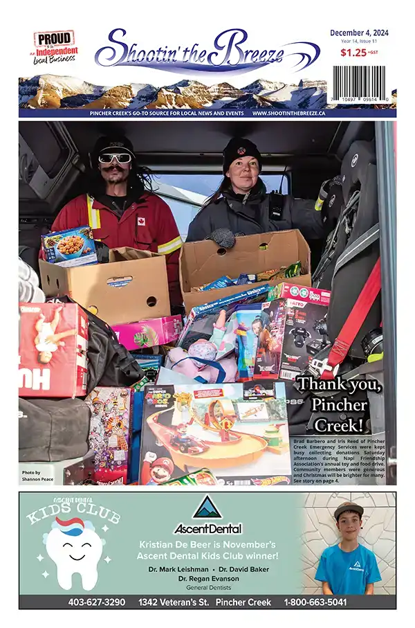 The front page of the Dec. 4, 2024, issue of Shootin’ the Breeze features Pincher Creek Emergency Services members Brad Barbero and Iris Reed inside a fire truck filled with donated food and toys. The headline reads “Thank you, Pincher Creek!” Below is an ad for Ascent Dental with the month’s Kids Club winner. Shootin’ the Breeze is a community newspaper and website covering Pincher Creek and area news and events in southwestern Alberta,
