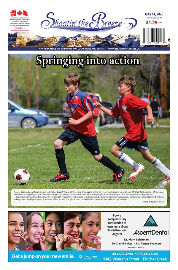 Front page of the May 14, 2025 issue of Shootin’ the Breeze. A U11 soccer player from Pincher Creek runs the ball upfield during a spring match against Elkford, kicking off the 2025 soccer season.