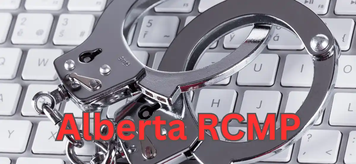 A pair of metal handcuffs rests on a computer keyboard, with the words "Alberta RCMP" in bold red letters across the image.