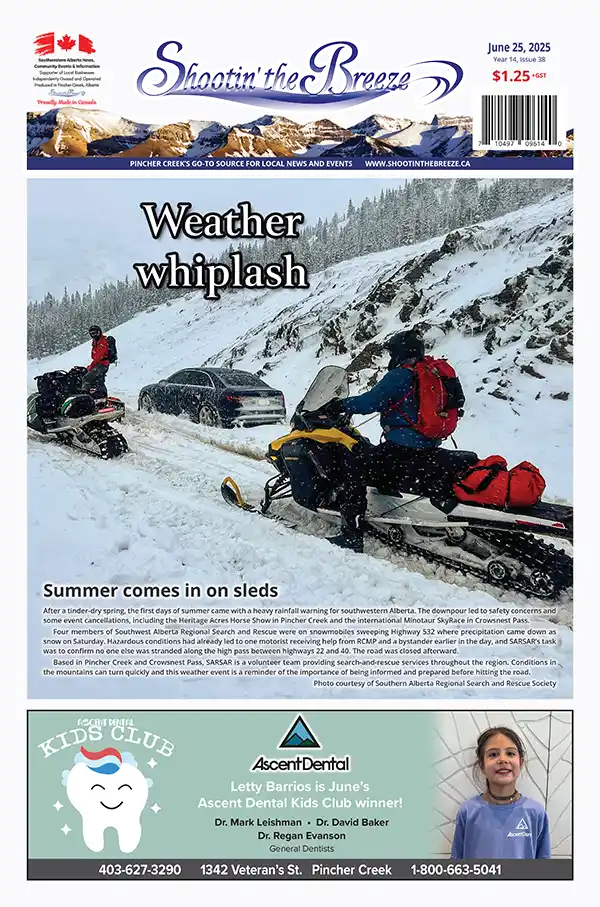 Two people on snowmobiles assist a car stuck in snow on a mountain road. Snow-covered pine trees and steep slopes surround the scene. The headline reads "Weather whiplash," with more text and a small dental ad below.