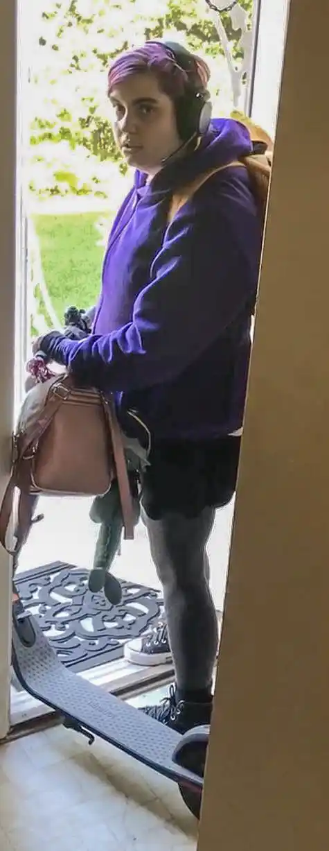 Missing person Lexxi Singer, 23, with bright pink hair wearing purple hoodie and headphones with backpacks